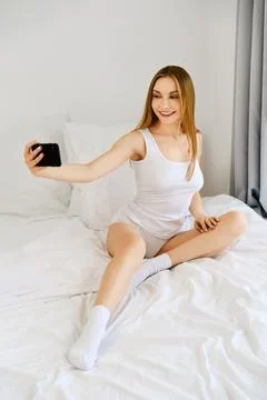 Opinionmaker makes selfie in bed Stock Photos