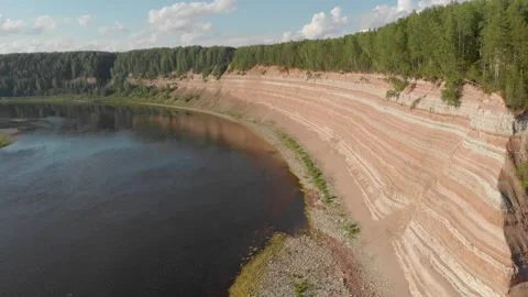 Opoki. Aerial view of a river flowing beside layered red cliffs Stock Footage 335967739