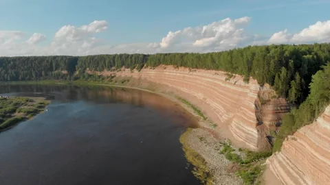 Opoki. Aerial view of a winding river beside a steep, layered cliff Stock Footage 335966616