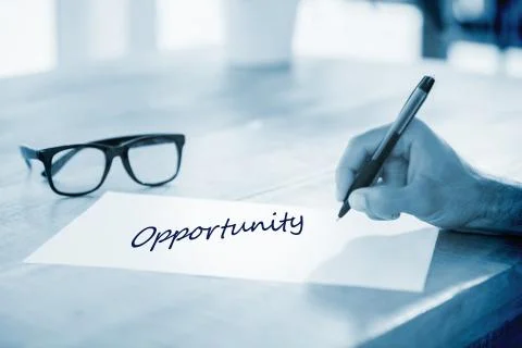 Opportunity  against side view of hand writing on white page on working desk Stock Illustration