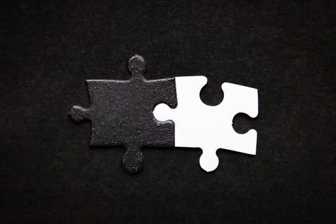 Opposite day concept using white and black puzzle pieces. Stock Photos