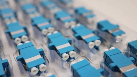 Optical adapters with different connectors in plastic blisters on the table Stock Footage 282983825