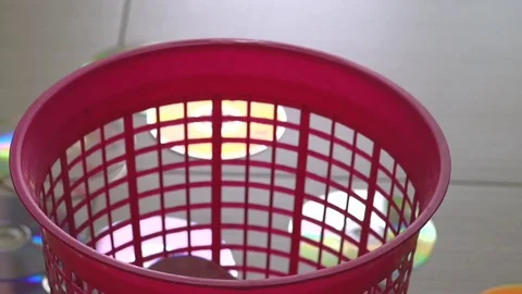 Optical DVD or CD Discs falling in to red trash bin. Time lapse Video stock 76611028