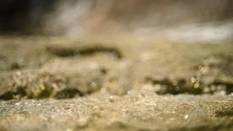 Optical effects of water flowing over rocks in the mountains (slow motion) Video stock 212747365