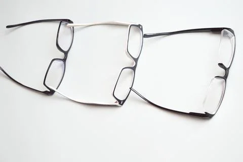 Optical glasses, in a black frame, lying in a row on a white background. Visi Stock Photos