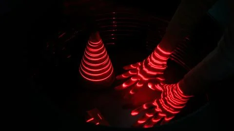 Optical illusion with red lasers, woman hand and geometric objects Stock Photos