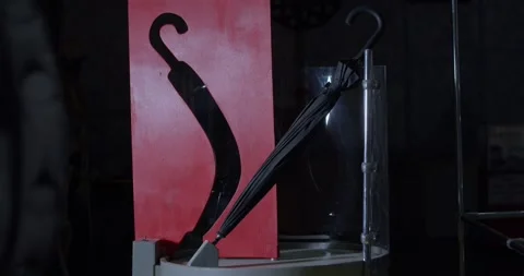 Optical illusion of an umbrella going through a crooked hole in the wall, 4k Stock Footage 156888756