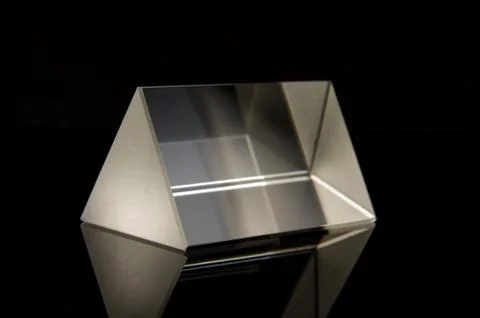 Optical prism for experiments isolated on the black background Stockfoto's
