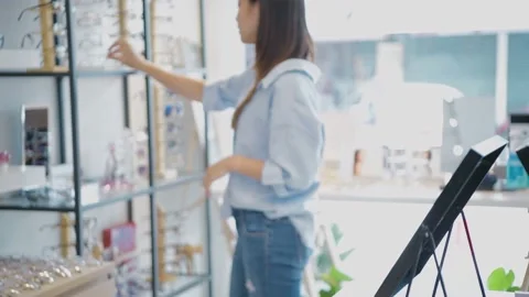 Optical shop concept of 4k Resolution. Young Asian women are happily choosing Stock Footage 144622522