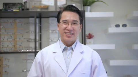 Optical shop concept. The ophthalmologist is explaining the selection of eyeg Stock Footage 139305149