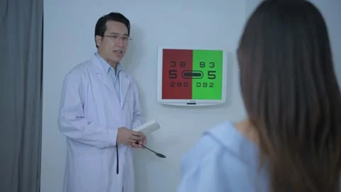 Optical shop concept. The ophthalmologist is testing a patient's eyesight by  Stock Footage 141289110