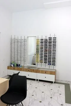 Optical store interior with large selection of eyeglasses on wall displays, s Stock Photos