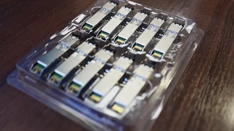 Optical transceiver modules in a blister pack on a table.  Video stock 282983730