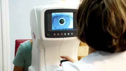Optician Conducting Eye Exam with Refractometer Stock Footage 305281712