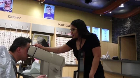 Optician giving man instruction how to do while testing eye vision Stock Footage 64928778
