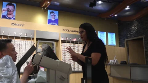 Optician giving man instruction how to do while testing eye vision Stock Footage 158680054