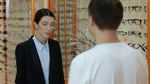 Optician helping customer to choose spectacles Video stock 74384365