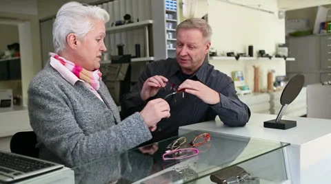 Optician helping senior customer finding glasses Stock Footage 23059549