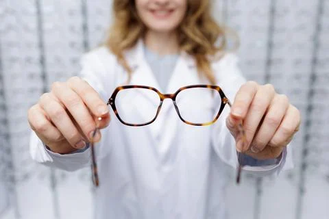 Optician presenting eyeglass frames to customer during prescription eyewear.. Stock Photos