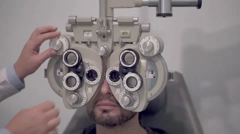 Optician setting a phoropter before a eyesight visit Stock Footage 56680215