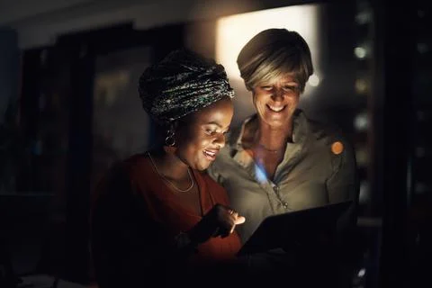 Optimising their time with technology. Shot of two businesswomen using a digital Stock Photos