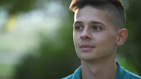 Optimistic brunet guy smiling and standing in a green park area in summer Stock-Footage 142483544