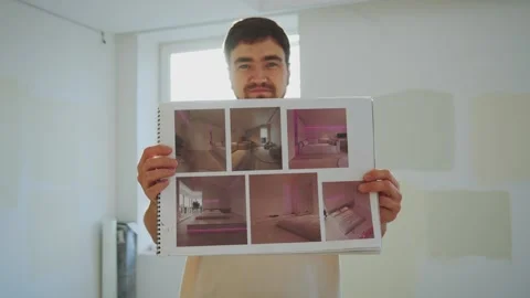 Optimistic caucasian man standing in room with ongoing repair, showing concept Stock Footage 243801216