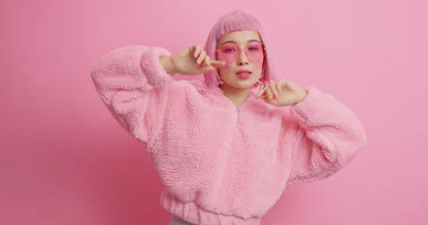Optimistic cheerful pink haired Asian woman dances with rhythm of music moves Stock Footage 147117040