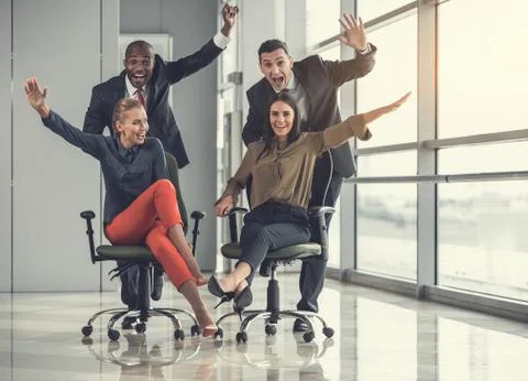 Optimistic comrades making competition in office Stock Photos