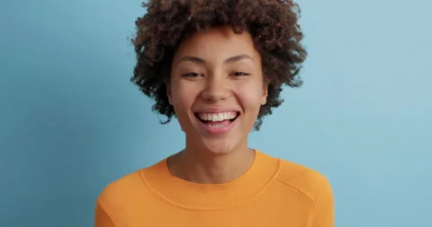 Optimistic dark skinned beautiful young woman with Afro hair laughs out loudly Stock Footage 143624519