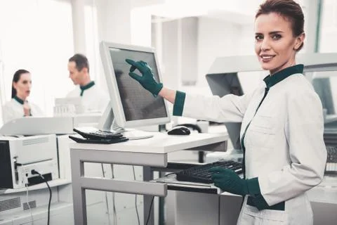 Optimistic doctor pointing at computer screen 스톡 사진
