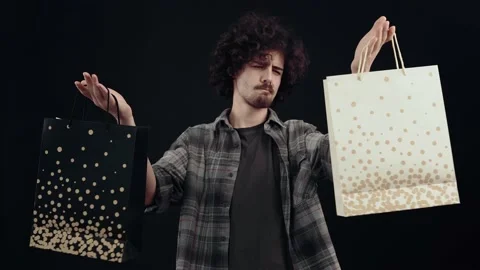 The optimistic hipster smiles broadly, picks up two packages, is happy and Stock Footage 155087823