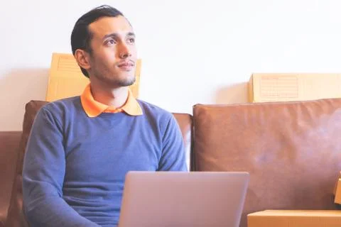 Optimistic home office worker using laptop on sofa Stock Photos