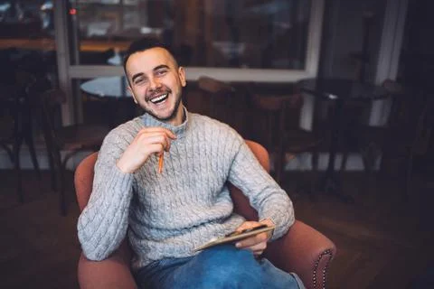Optimistic man writing ideas in cafe Stock Photos
