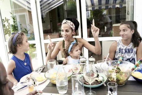 Optimistic mother pointing up at lunch table Stock Photos