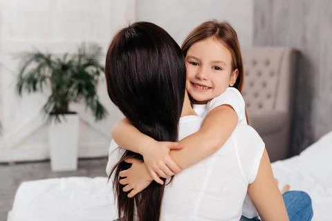 Optimistic pleasant child embracing young woman Stock Photos