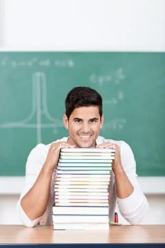 Optimistic student with a stack of textbooks Stock Photos