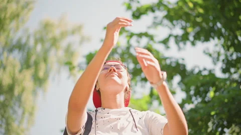 Optimistic student standing beneath leafy branches and bright sky, Asian youth Video stock 327236363
