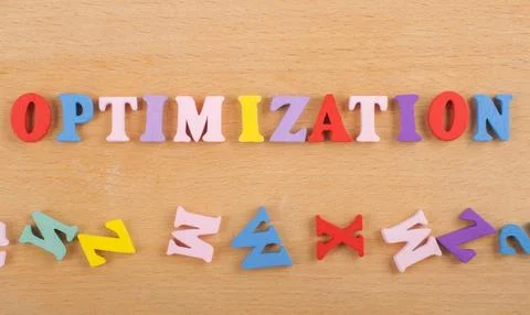 OPTIMIZATION word on wooden background composed from colorful abc alphabet .. Stock Photos