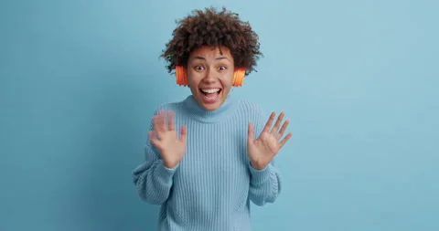 Optimstic successful dark skinned young woman hears awesome track in wireless Stock Footage 144916253