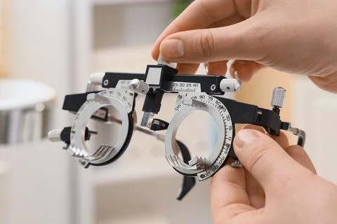 Optometrist adjusting phoropter trial frame for vision test, eye examination, Stock Photos
