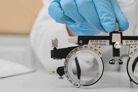 Optometrist adjusting phoropter for vision test, eye care examination and ref Stock Photos