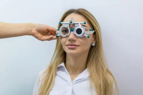 Optometrist adjusting trial frame during professional eye examination Stockfoto's