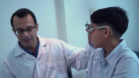 Optometrist doing sight testing for child patient in clinic Stock Footage 165632038