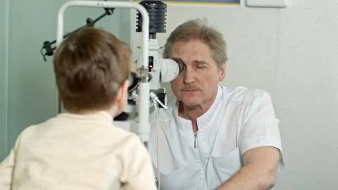 Optometrist doing sight testing for little pateient Stock Photos