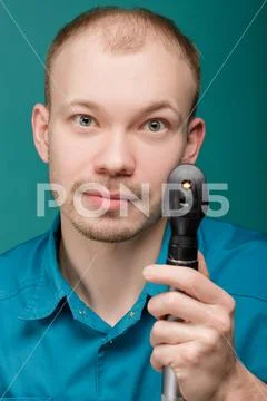 Optometrist with ophthalmoscope, instrument to look into eyes by doctor on blue Stock Photos