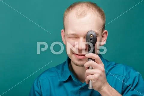 Optometrist with ophthalmoscope, instrument to look into eyes by doctor on blue Stock Photos