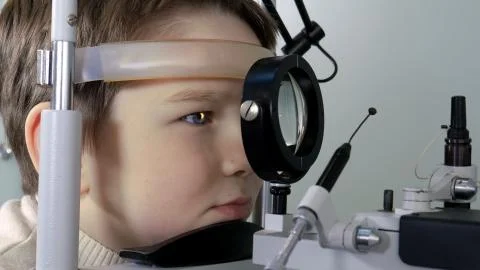 Optometrist performing visual field test of young boy Stock Photos