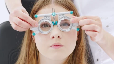 Optometrist performs vision test for patient Stock Footage 336610332