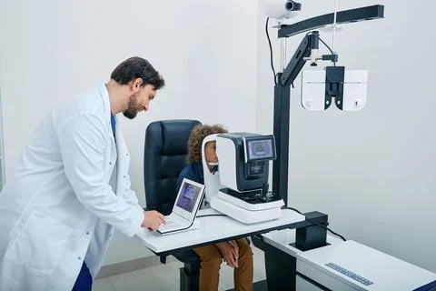 Optometrist using autorefractor determining required level of vision correc.. 库存照片